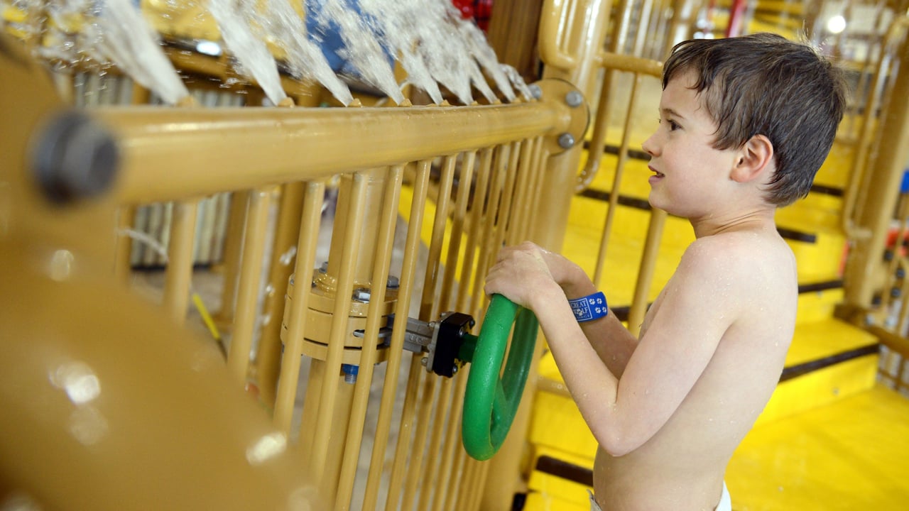 child playing with water cannons