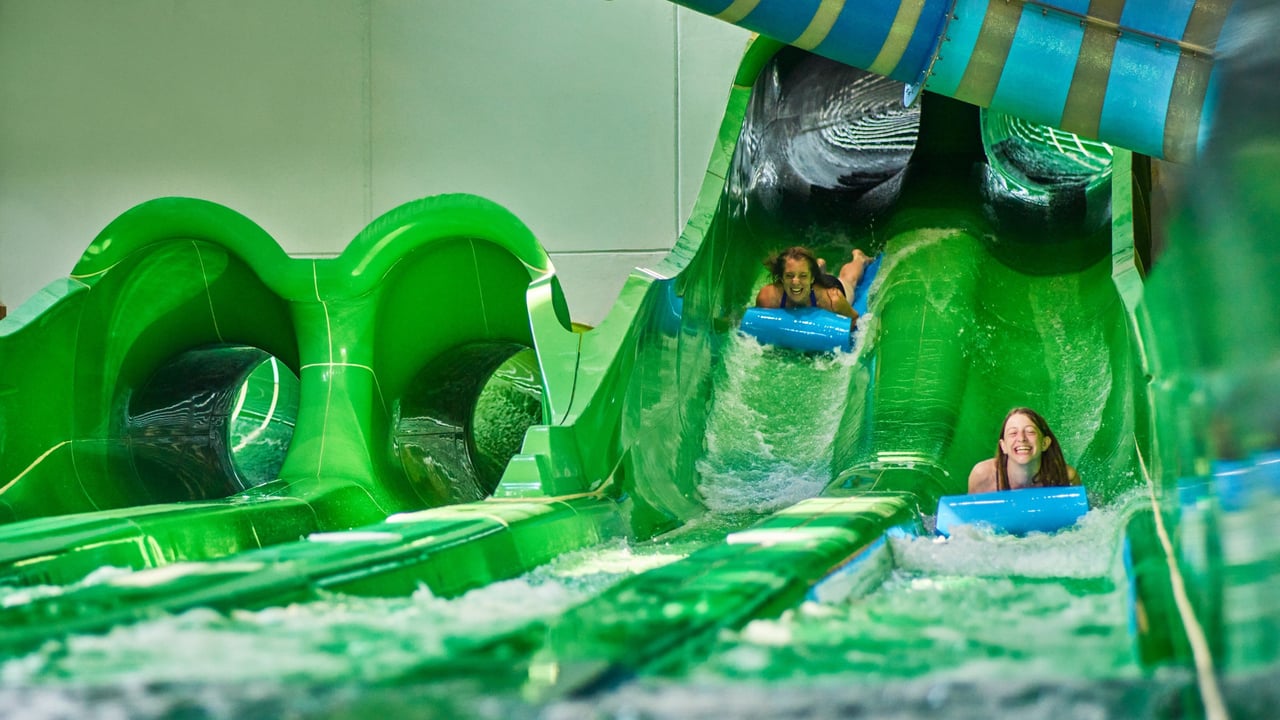 Girl landing in the stopping area of the mat racer slide