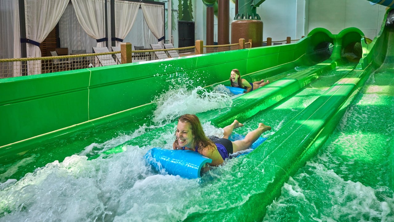 mother on a green mat water slide