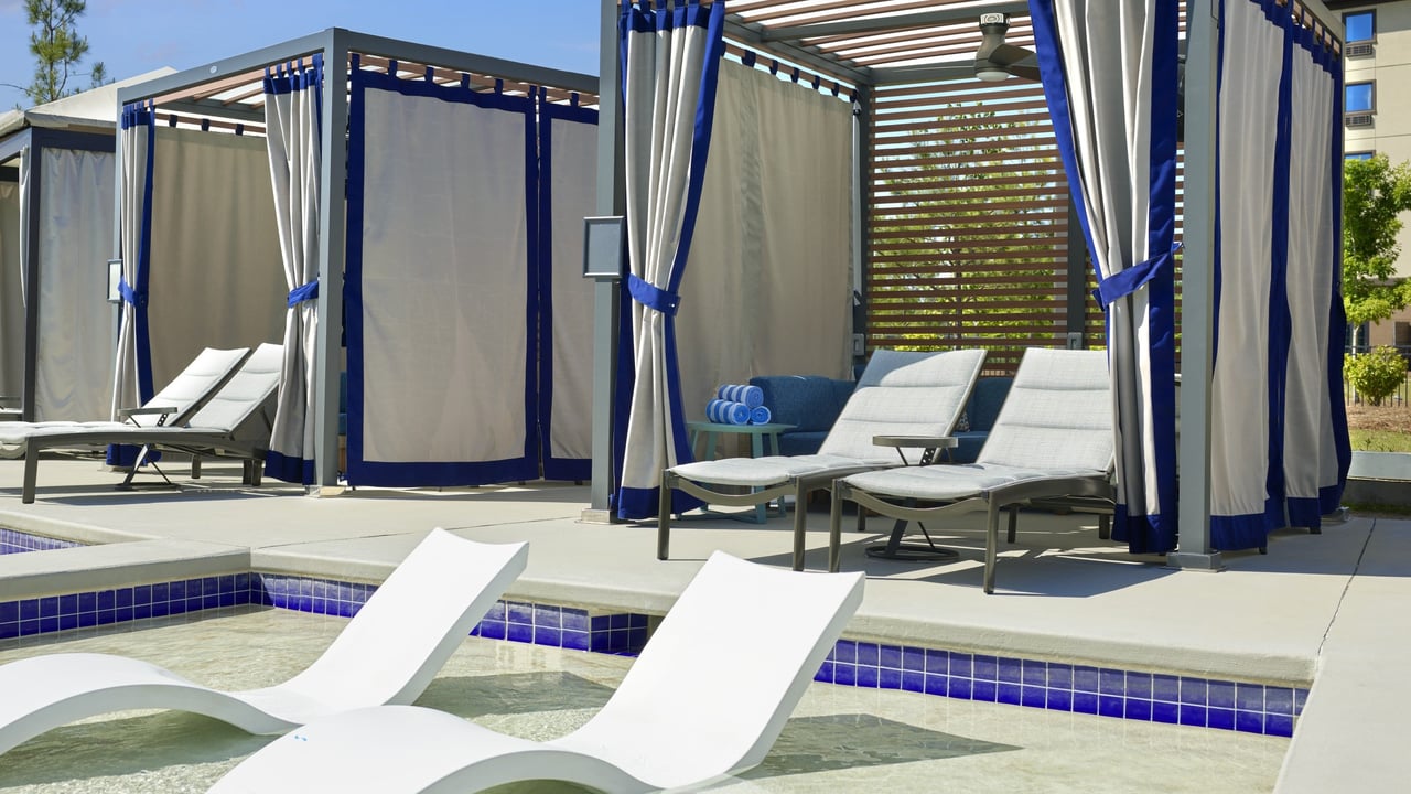 several outdoor cabanas with beach chairs