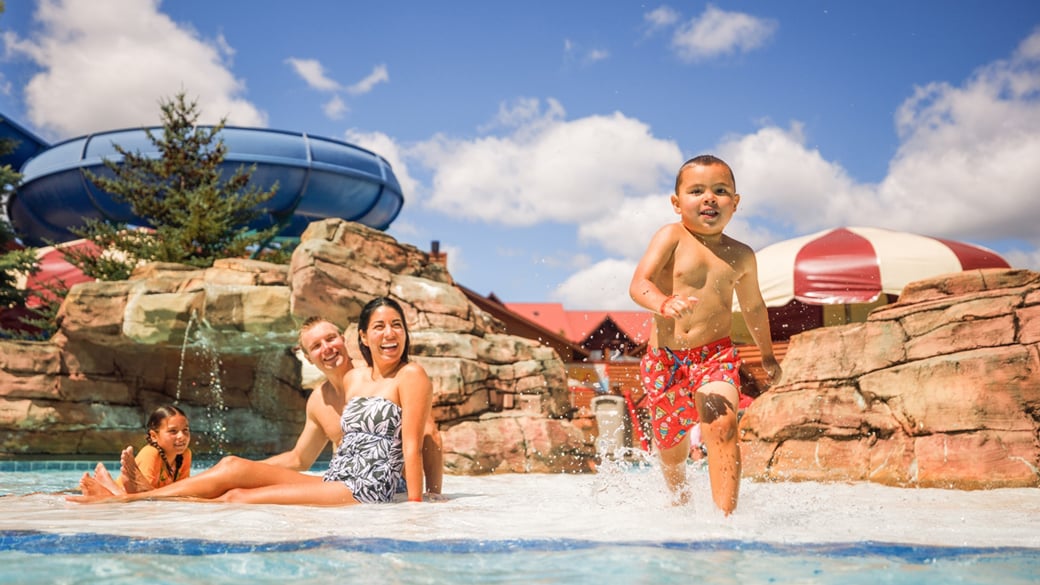 family of four lounging in an outdoor pool