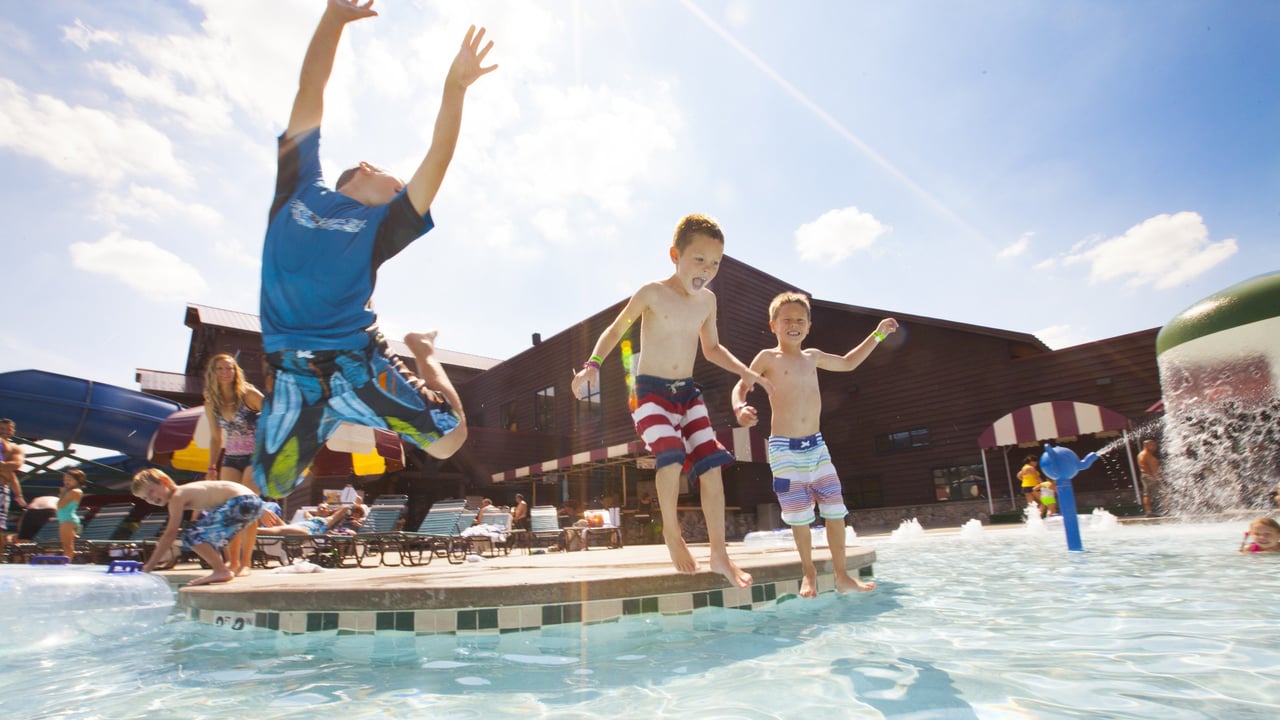 boys jumping in a swimming pool