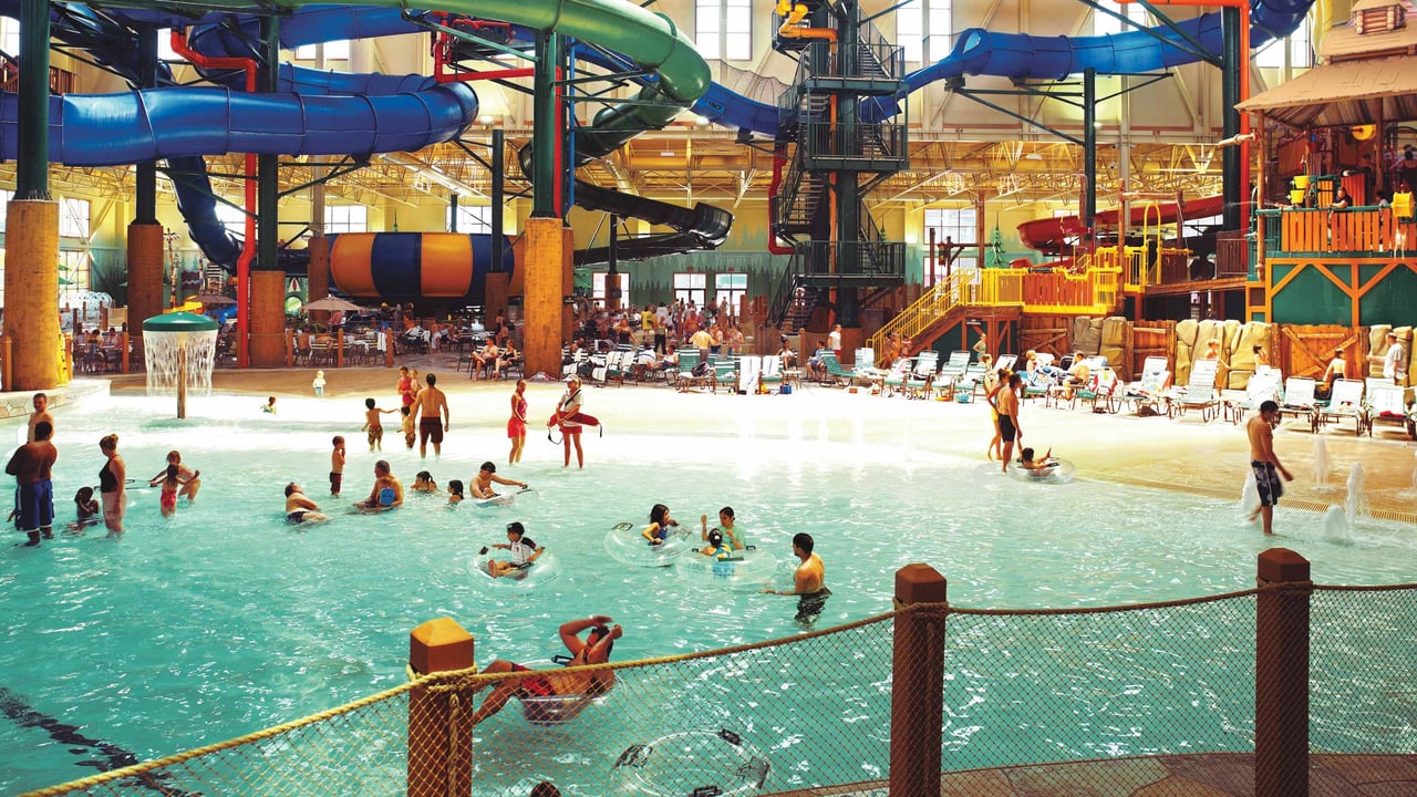 Families playing in the wave pool beneath the water slides.