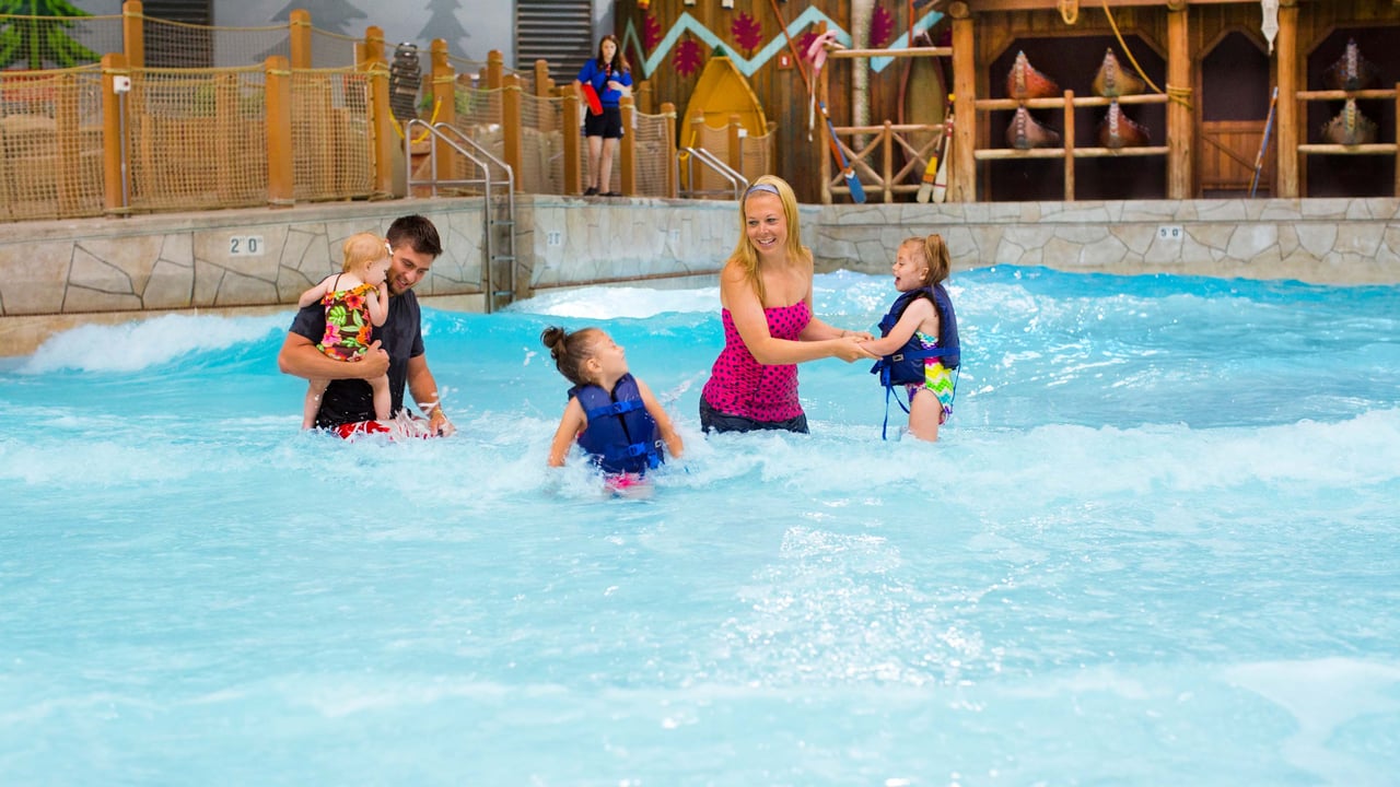 A family of 5 playing in the wave pool.