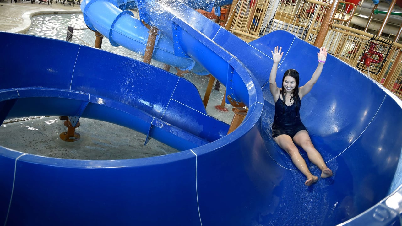 woman going down a blue body water slide in Anaheim CA