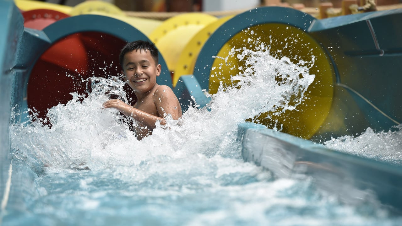 Teen going down a body water slide