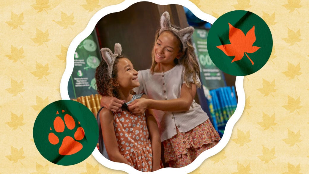 Big sister putting on a cape on her little sister