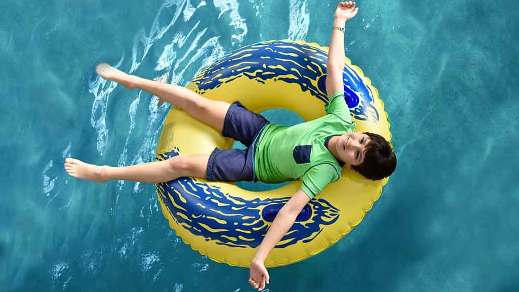 Youg boy floating on a green float at Great Wolf Lodge