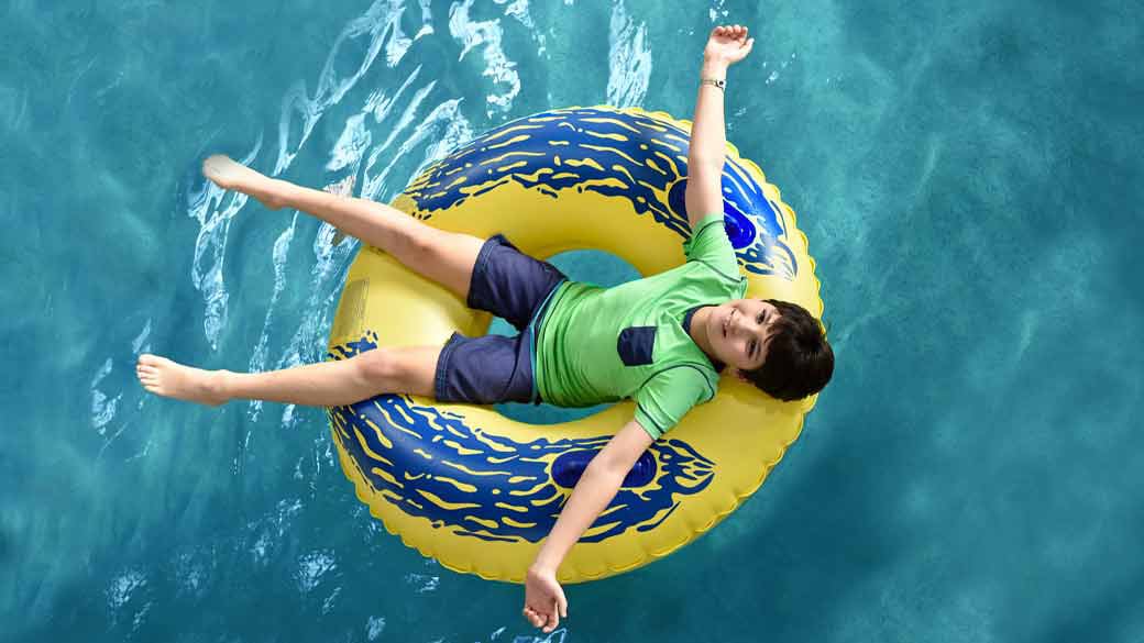 A young boy enjoying a lazy river on a yellow float at Great Wolf Lodge