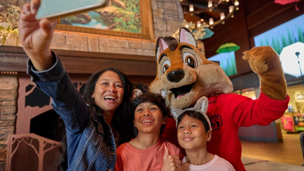 Mom and two children taking a selfie with Wiley the Wolf.