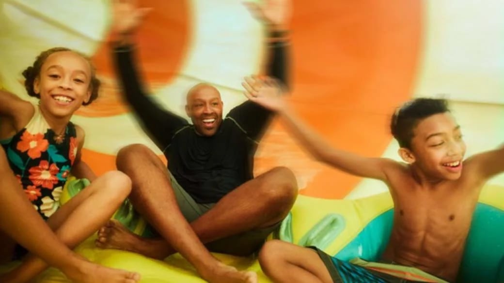 Parents sliding down a water slide