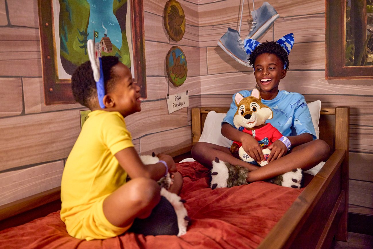 kids sitting on bunk bed in a cabin themed suite