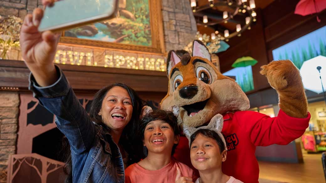 family getting a selfie with a great wolf lodge character