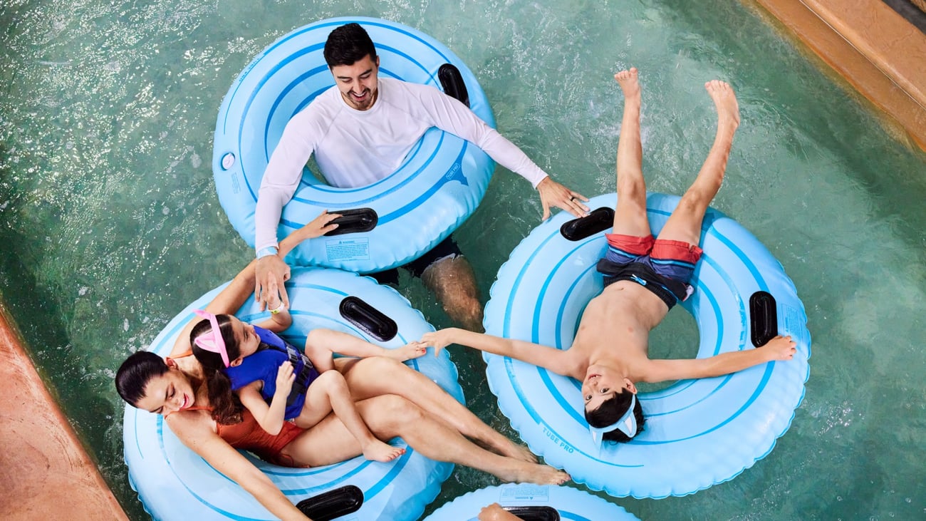 family flotaing on tubes in lazy river
