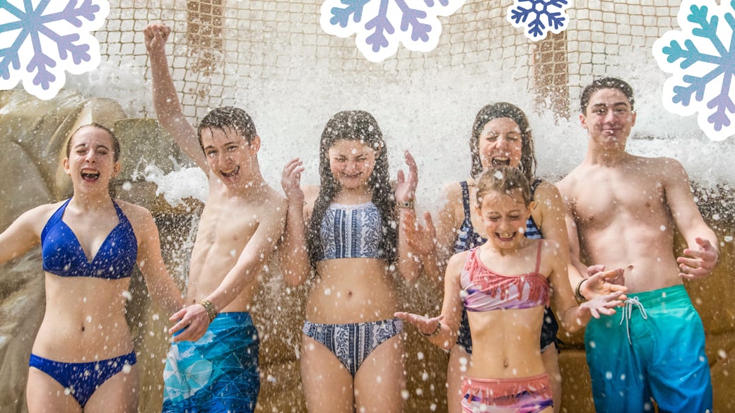 teens standing under a waterfall