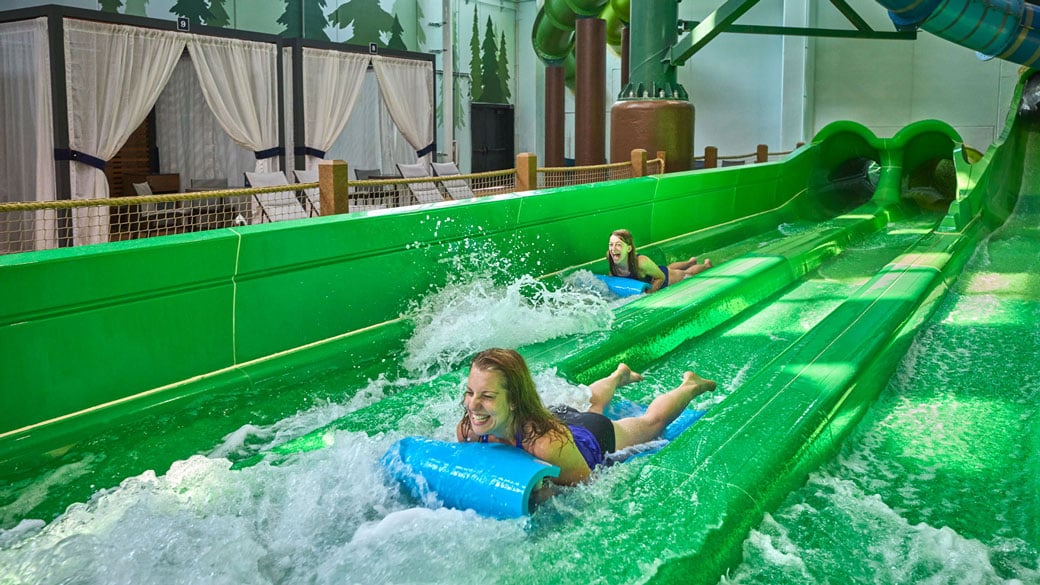 Mother and daughter sliding down a water slide in a blue slider 