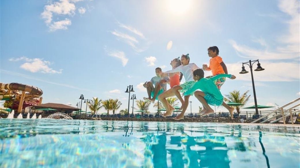 Kids jumping into an outdoor pool at Greatwolf Lodge