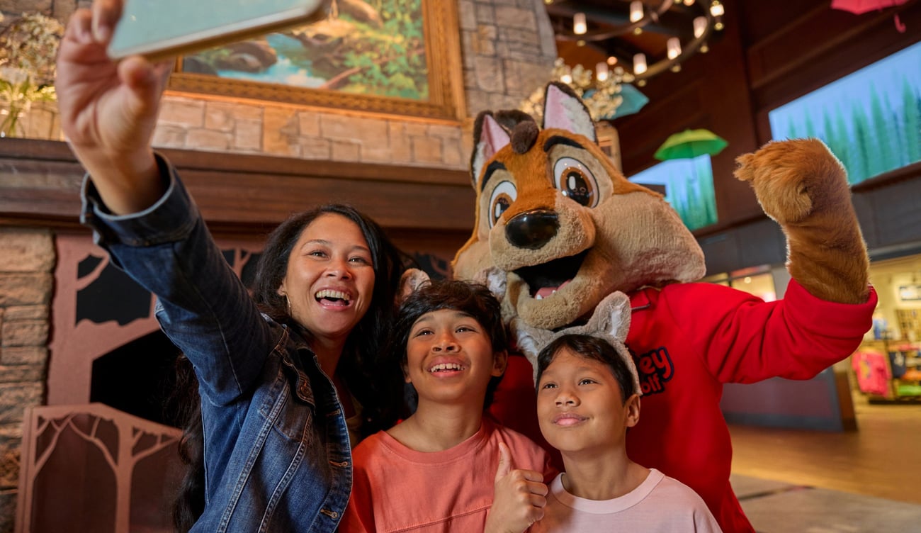 family taking a selfie with great wolf lodge character