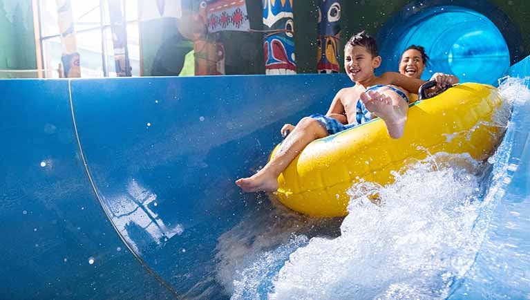Mother and son having fun riding the tube