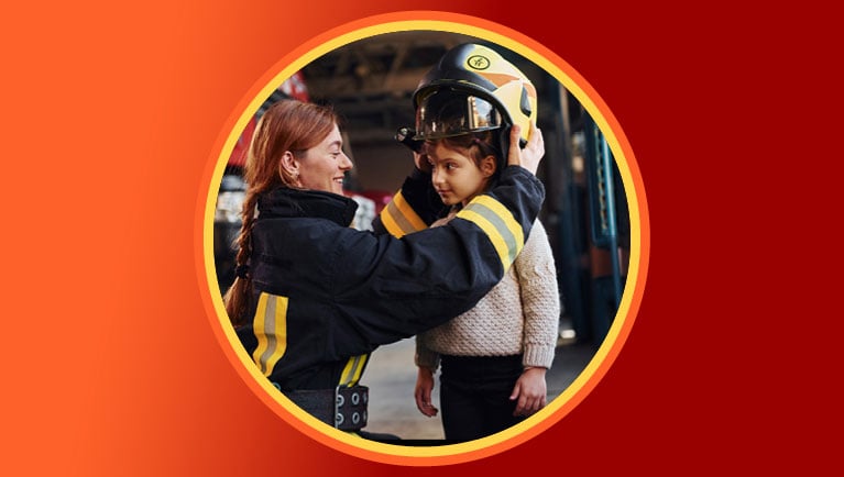 firefighter putting her helmet on a little girl