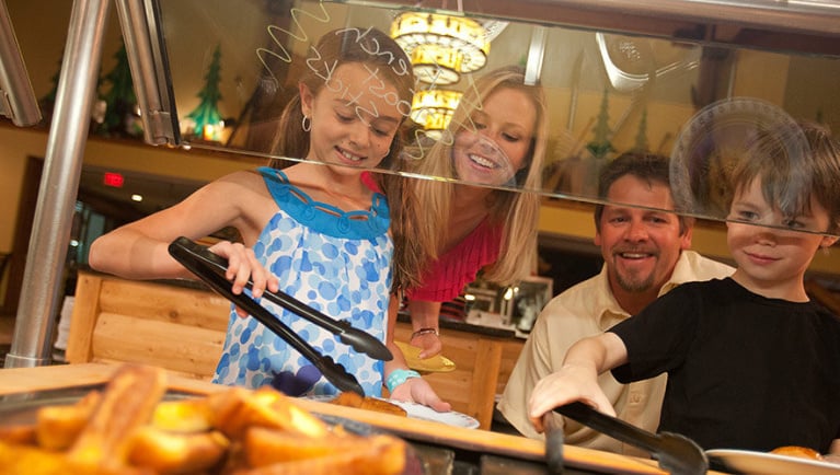 Kids use tongs to grab food at the Antler Shanty buffet at Great Wolf Lodge indoor water park and resort..