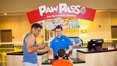 A father and son at the Howl at the Moon Mini Golf counter at Great Wolf Lodge indoor water park and resort.