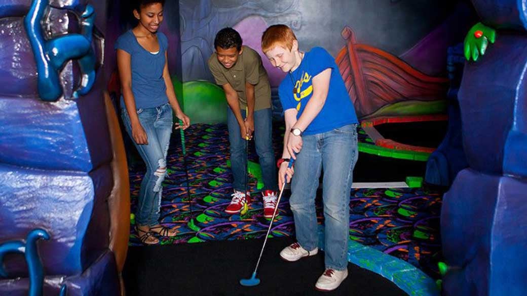 teenagers play a round of mini golg