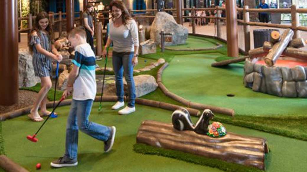 A family plays a round of mini golf at Great Wolf Lodge indoor water park and resort.