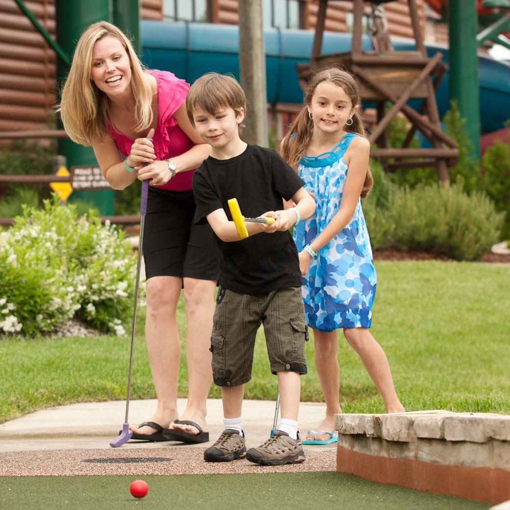 A family plays a round of mini golf 