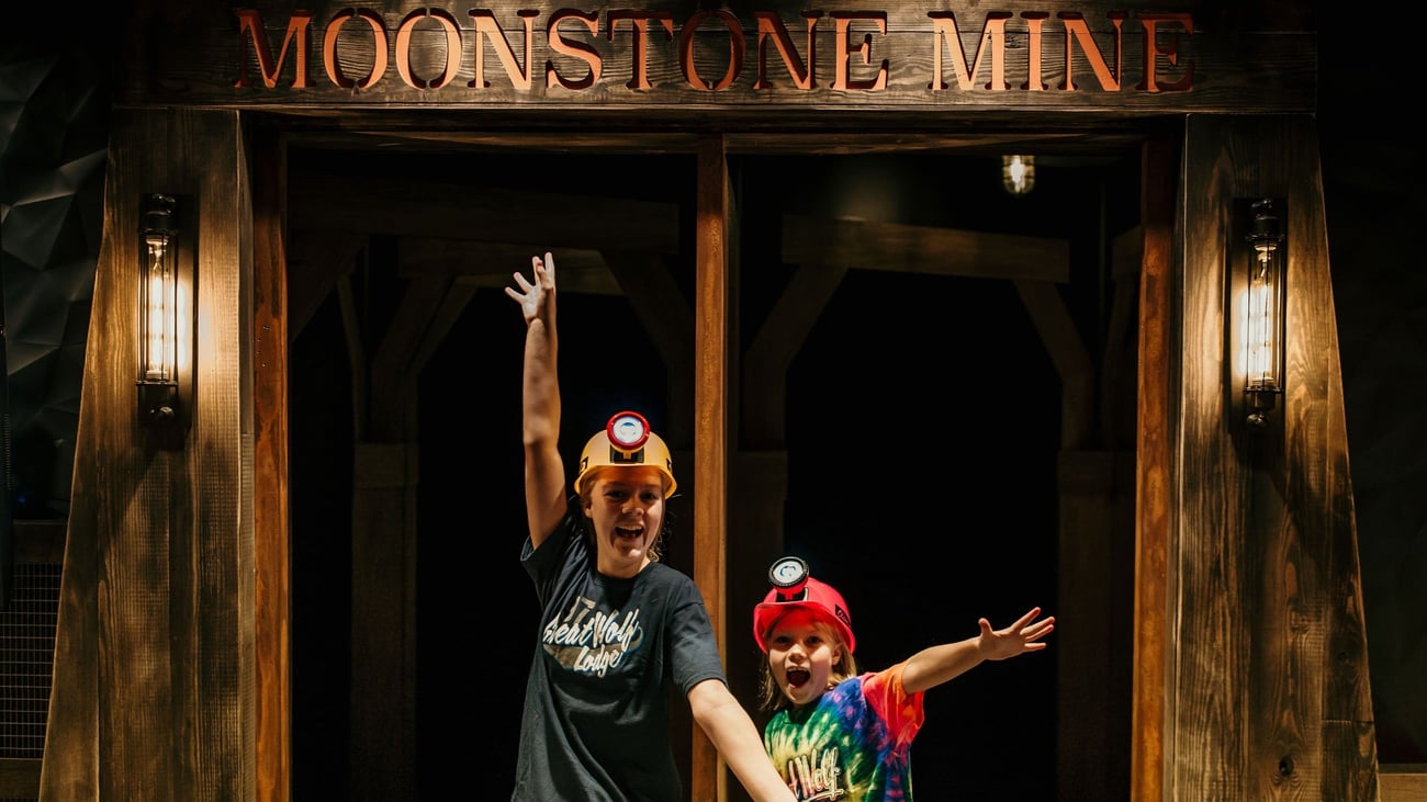 Two kids posing excitedly in front of Moonstone Mine