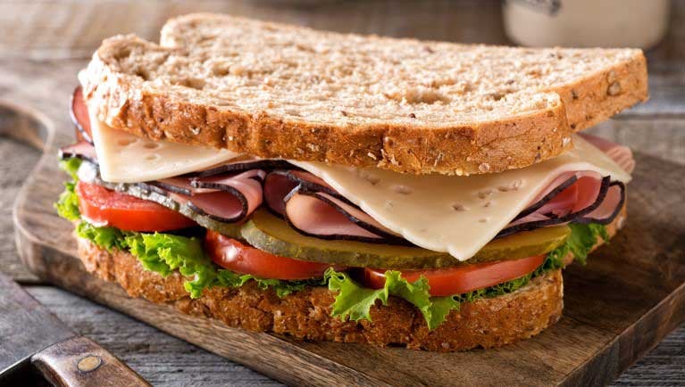 Sandwiches filled with lettuce, tomato, cheese and turkey.