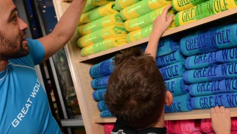 father and son shopping for Great Wolf themed towels