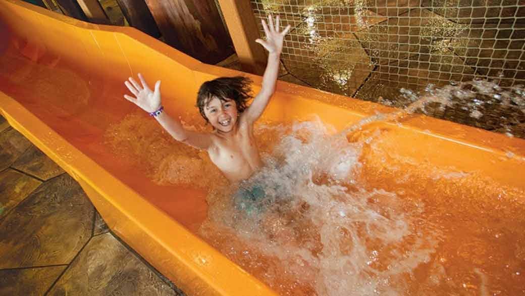 Child splashes going down the Beaver Falls at Great Wolf Lodge indoor water park and resort.