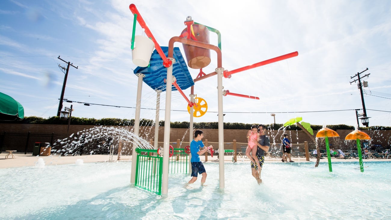 Kids play behind the outdoor water features 