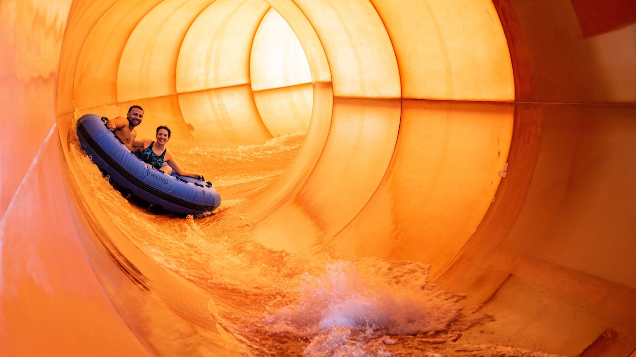 Couple on a blue raft going down a water slide