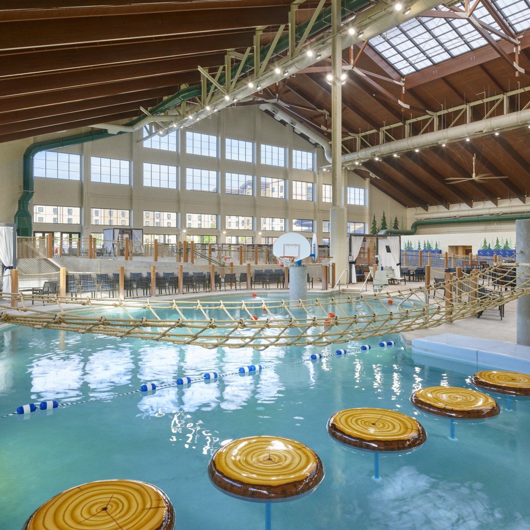 Indoor water park scene with a rope bridge