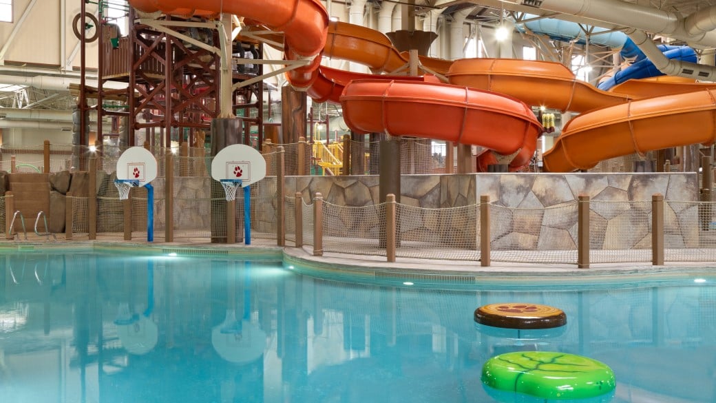 family playing basketball in indoor pool 