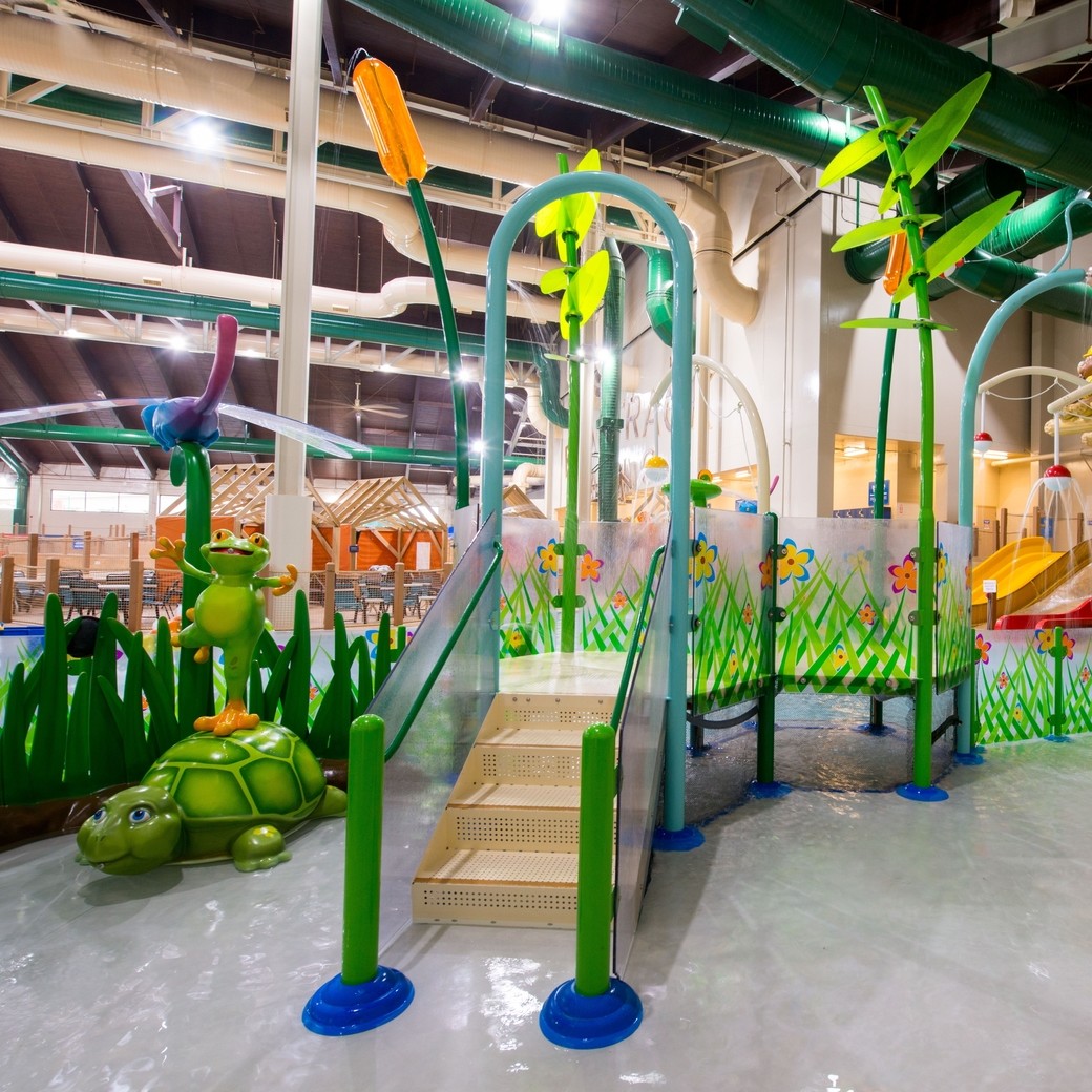 A vibrant water park featuring a large slide and a fun water play area for children.