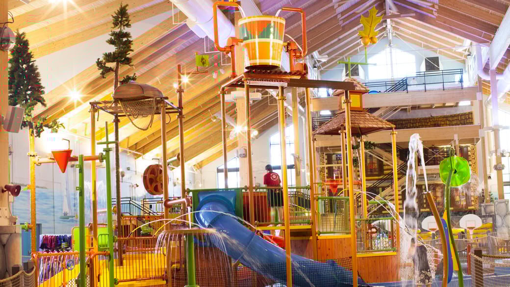 A wide shot of the  water treehouse as water splashes down from a bucket above the jungle gym