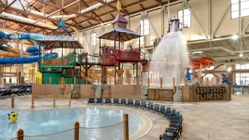 A wide shot of the  water treehouse as water splashes down from a bucket above the jungle gym