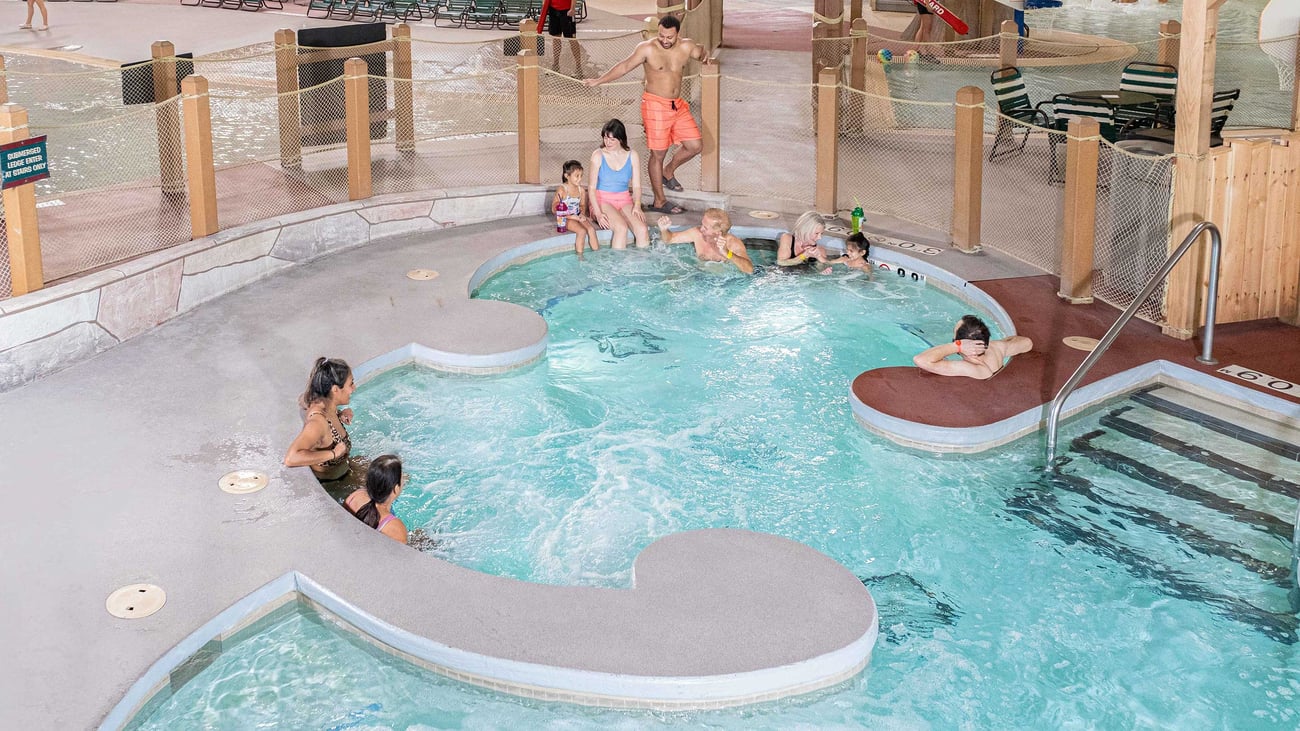 A family relaxes in an indoor hot tub