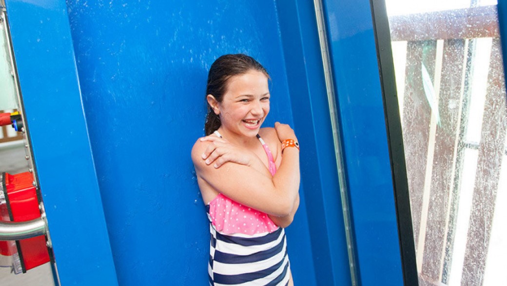 A girl smiles as she stands in line for the waterslide 