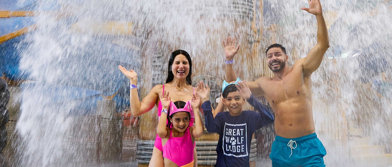 family standing under water bucket splashing water 
