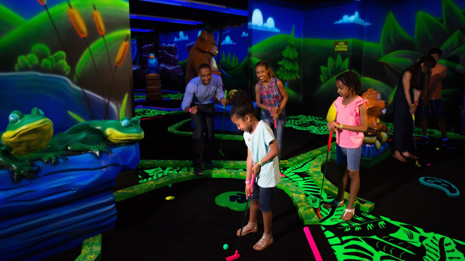 Family looking on as the son putts