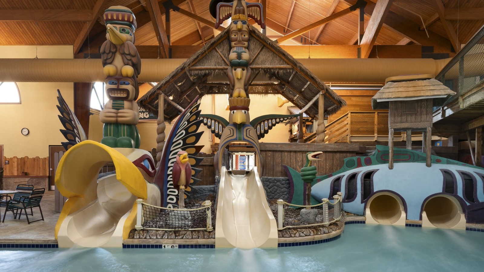 little boy about to go down a yellow water slide