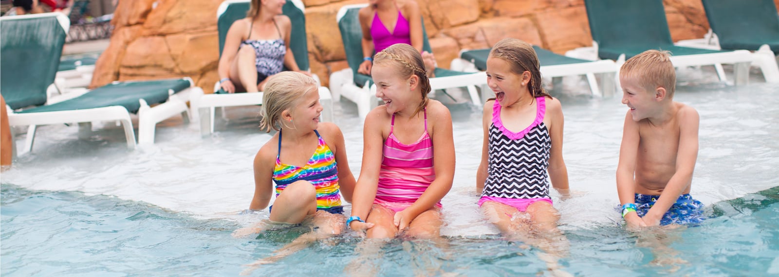 kids laughing sitting by pool side