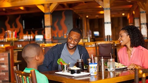 A family smiles as they share a dinner.