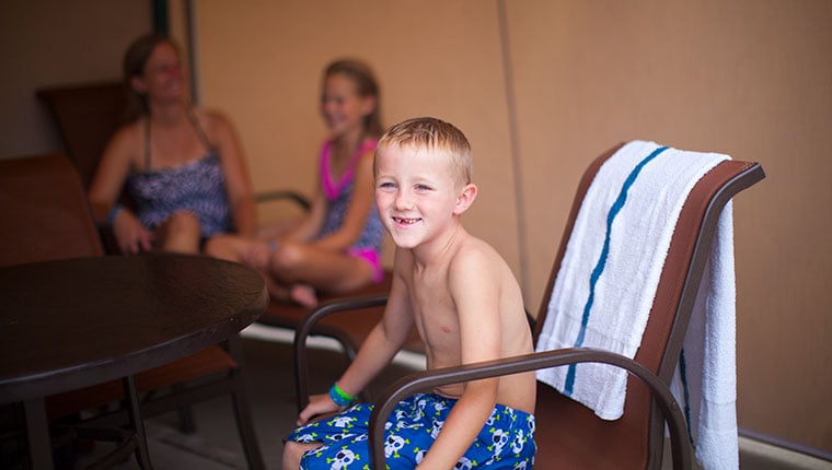 A boy smiles in a cabana at Great Wolf Lodge indoor water park and resort.