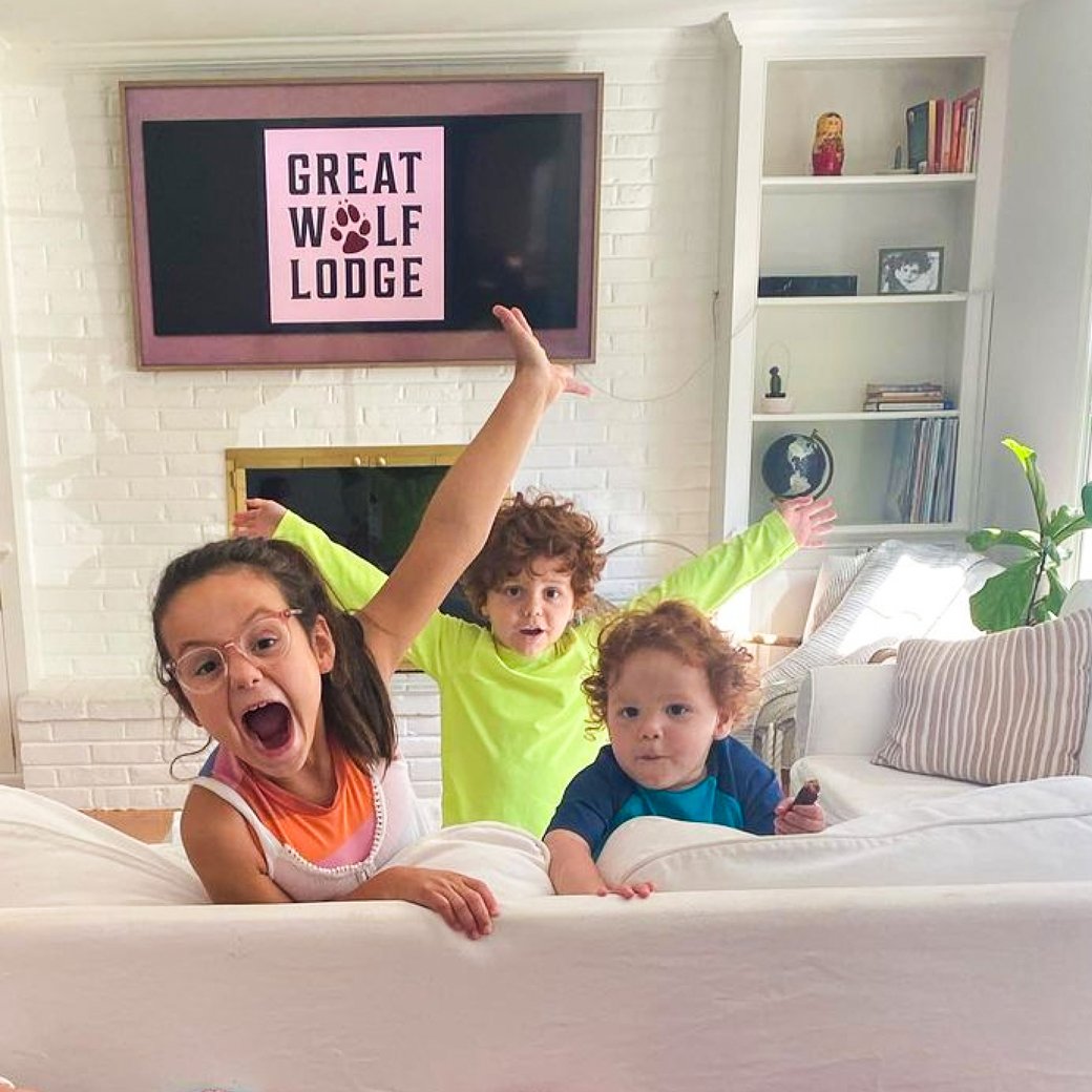 3 kids smiling while waiting in their living area