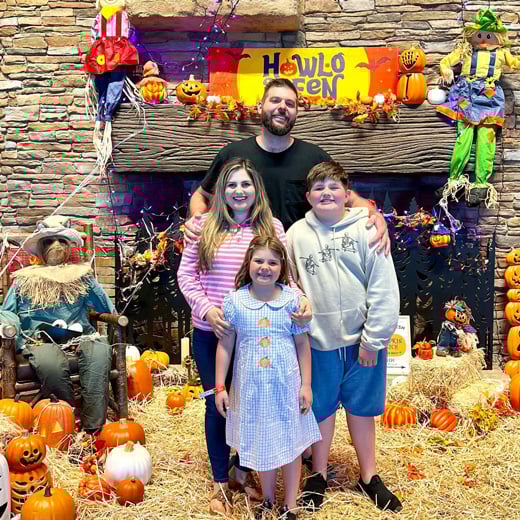 family posing in front of a halloween decor